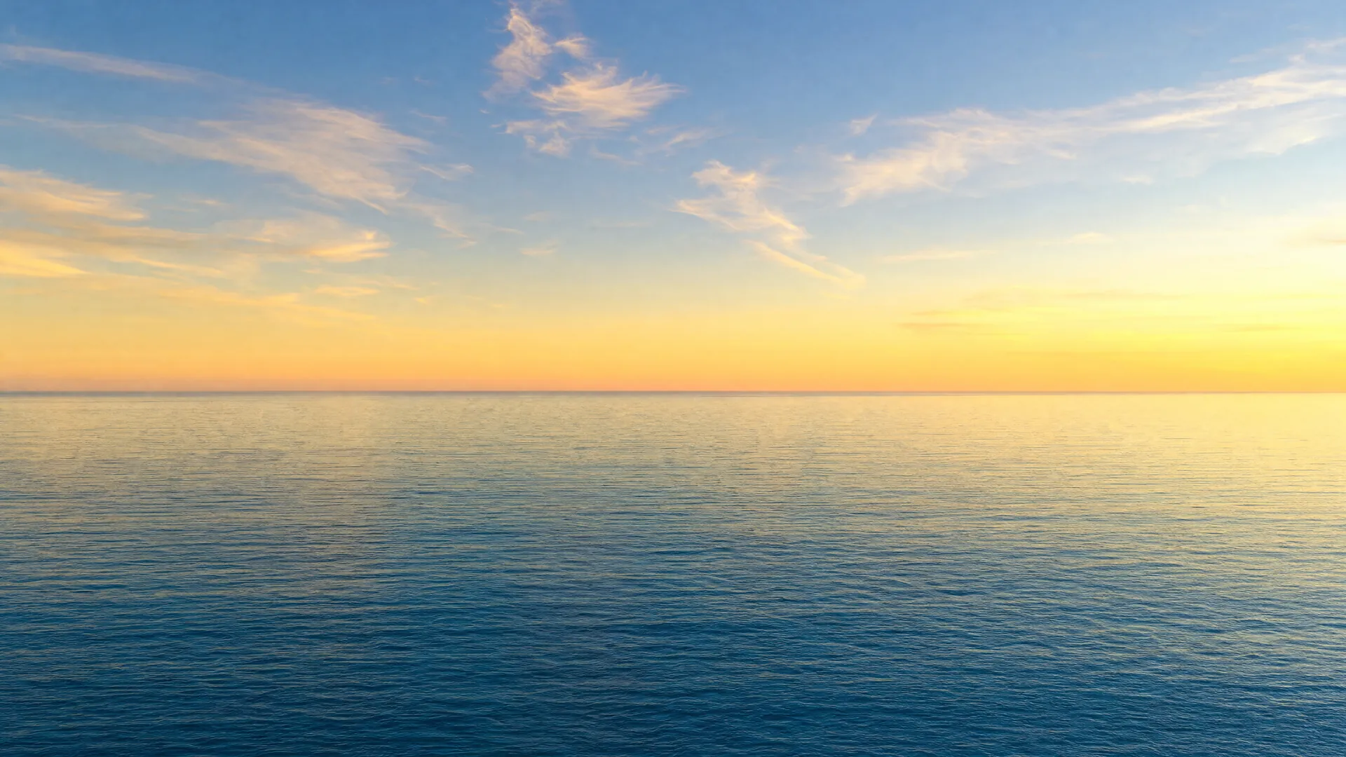 El horizonte del mar de Cortés al amanecer, con agua quieta y una franja de cielo dorado